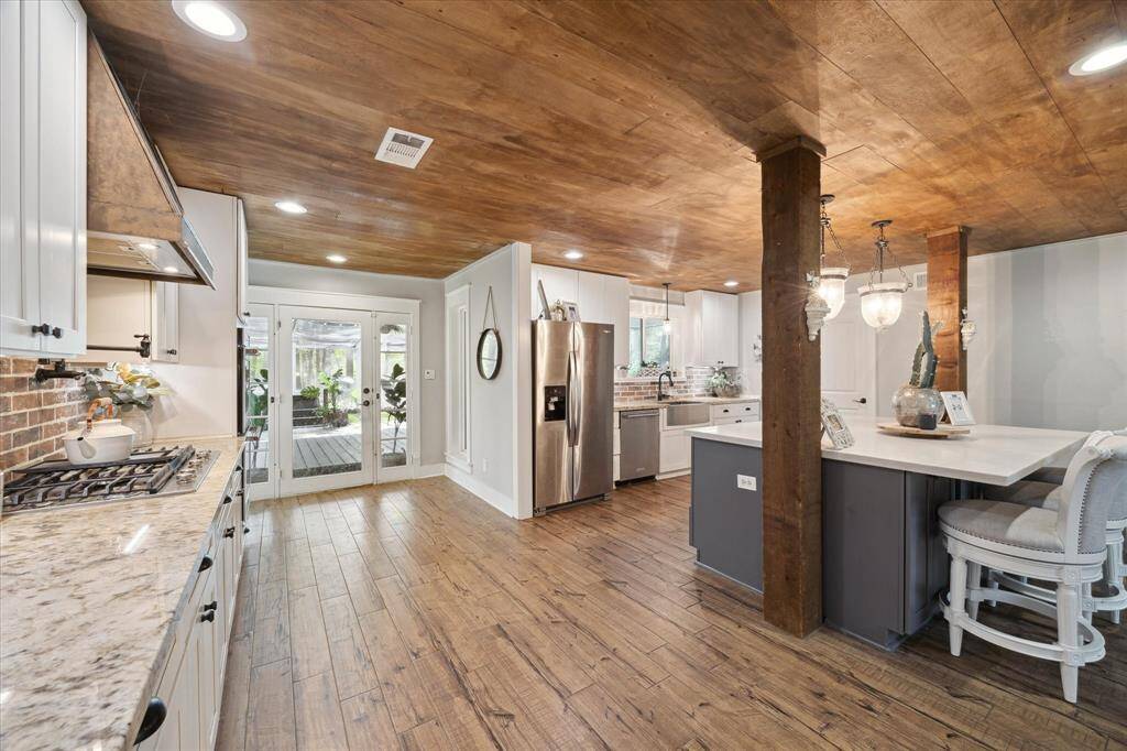 Brick accent wall with an instant pot filler and gas 5-burner cooktop.