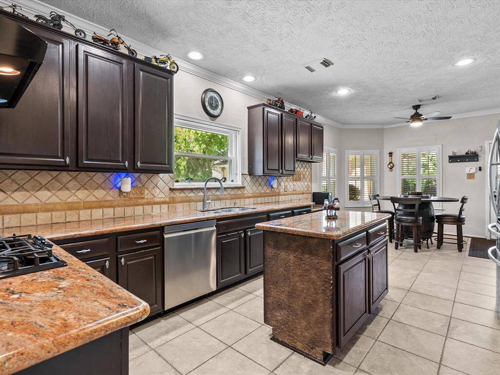 Accessible from the family room and the formal dining room, this kitchen showcases earth toned granite and stone tile backsplash