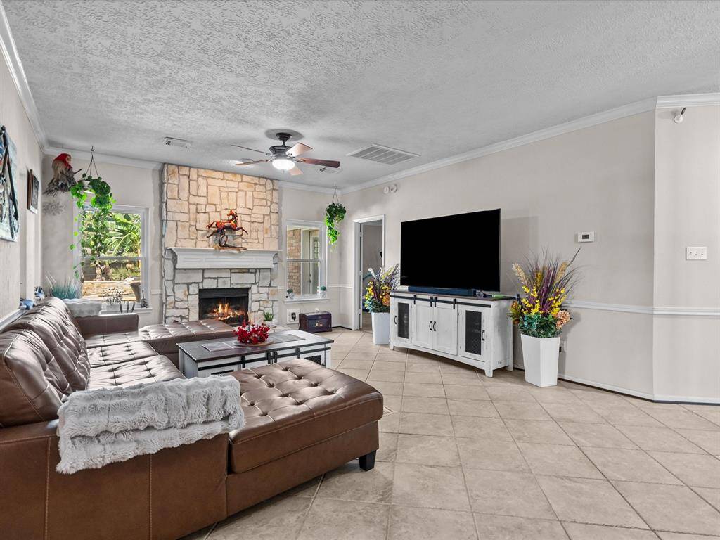 Downstairs is your family living quarters with a gas long fireplace, crown molding, and ceramic tile floors