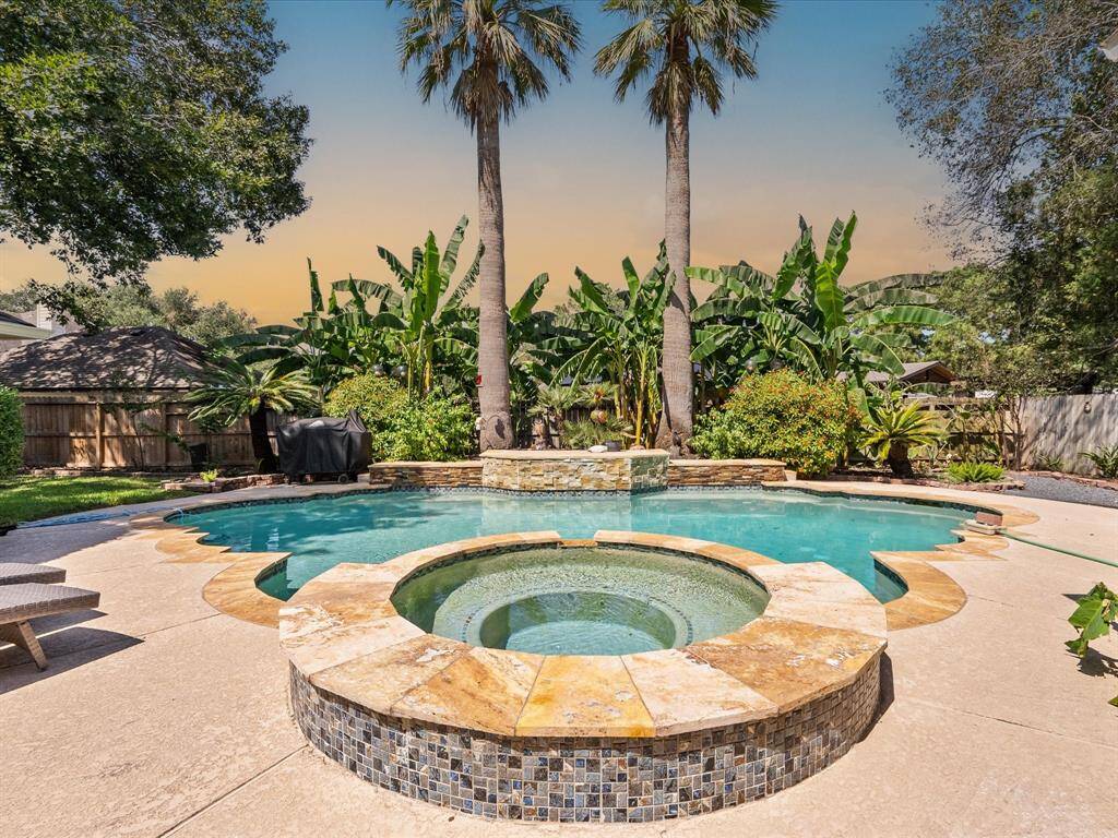 The raised spa features travertine coping, mosaic tile for fine detailing.