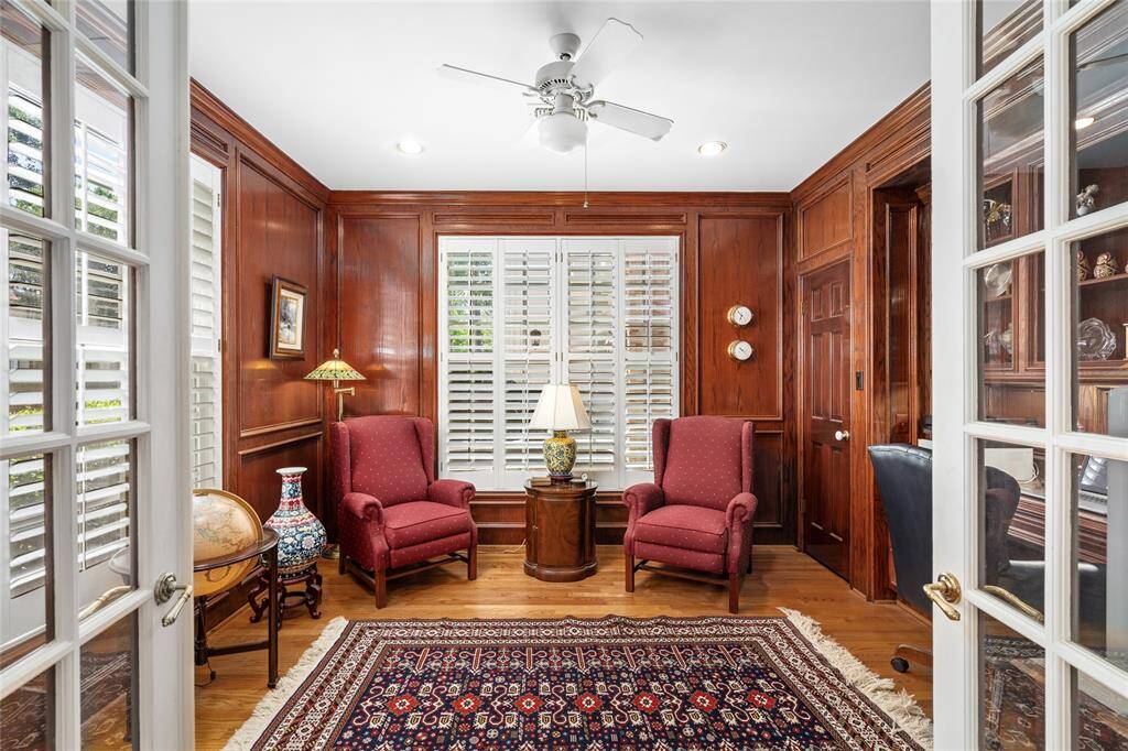 Inviting study with wood paneling & built in bookshelves.