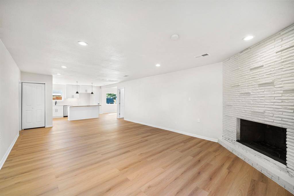 Entering into the spacious living area with the mid-century fireplace, new flooring and led lighting.