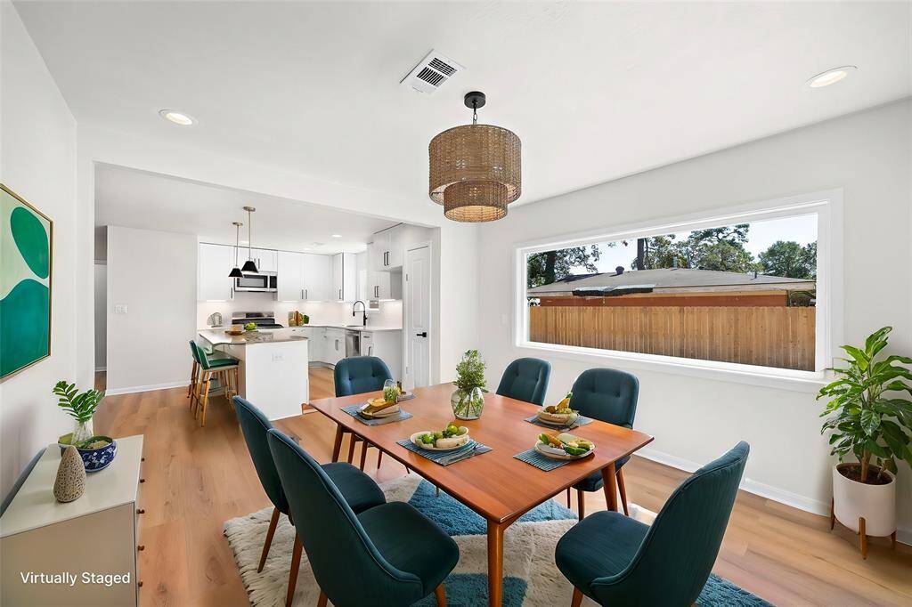 Light and bright dining area with custom light fixture and massive picture window.