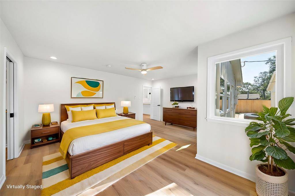 Virtually staged primary bedroom with en suite and large walk in closet.