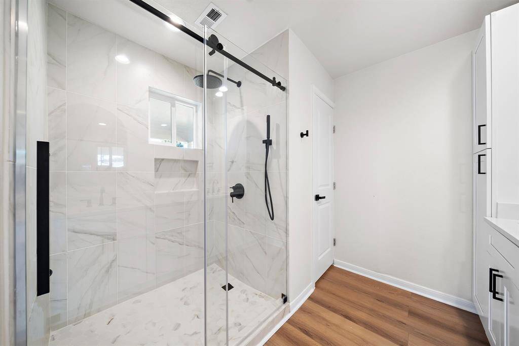 Walk in shower of primary bath and door to water closet.