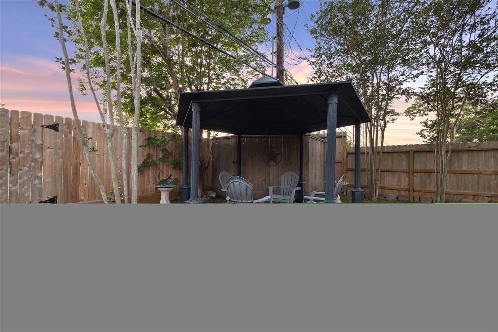 Backyard has a covered pergola.