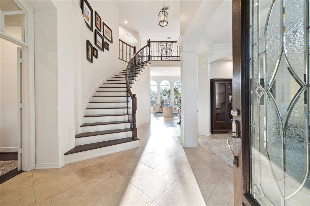 The living room has large windows and overlooks the backyard and is just off of the kitchen. The second set of stairs separated the kitchen and living room.