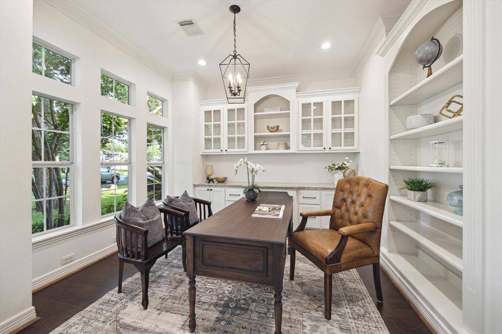 The living room has large windows and overlooks the backyard and is just off of the kitchen. The second set of stairs separated the kitchen and living room.