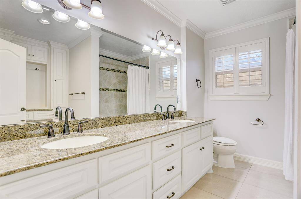 The hallway bathroom, shared by the two secondary bedrooms, offers two vanities, a tub/shower combo, and more built-in storage.