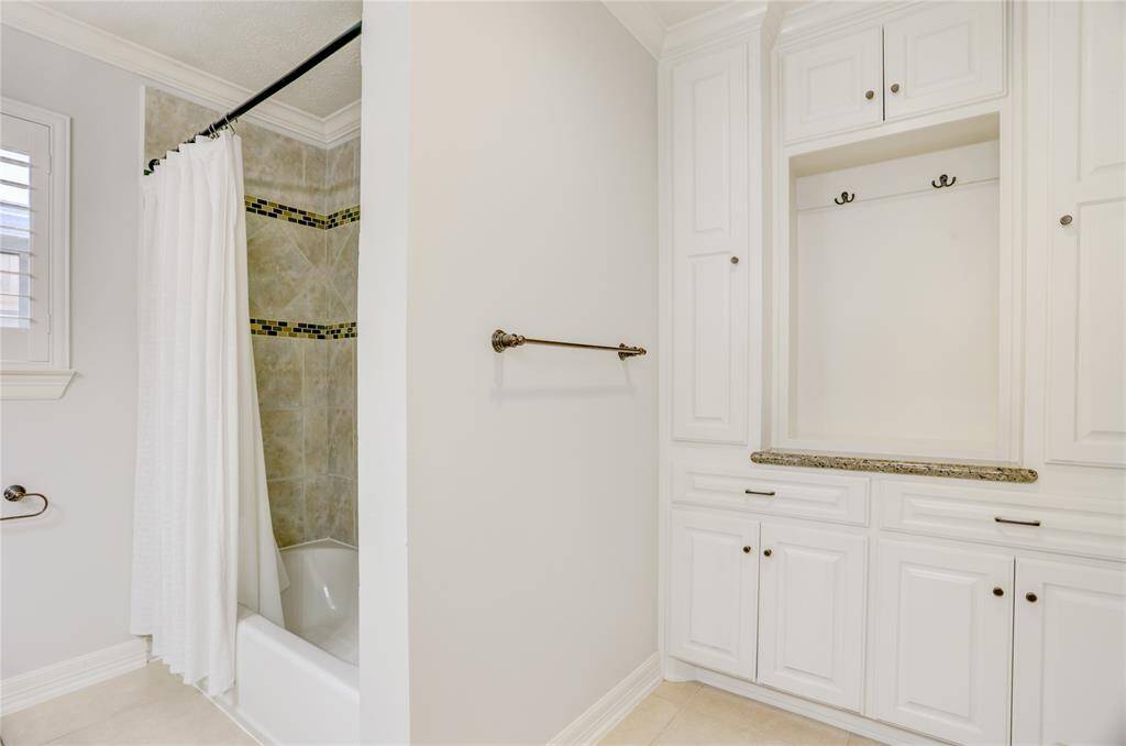 A photo of the hall bath tub/shower and built-in storage.