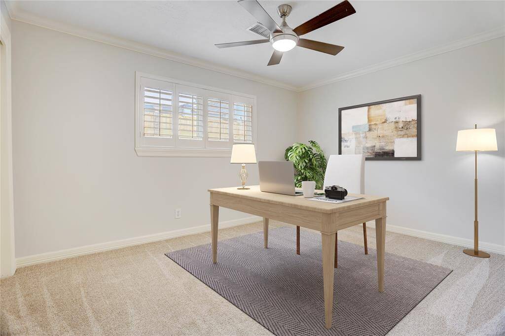 The middle bedroom is ideal for a home office, like this virtually staged photo, a kid's room, or additional guest bedroom.