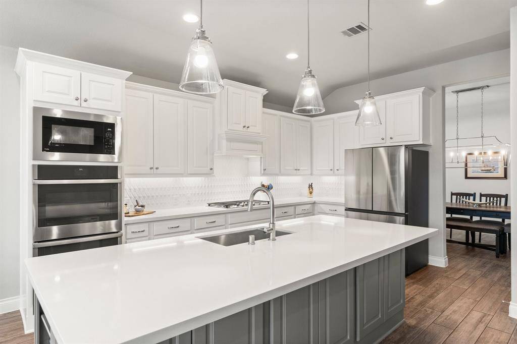 Gorgeous quartz island with pendant lighting. Plus, Double ovens and a 5 burner gas cooktop!