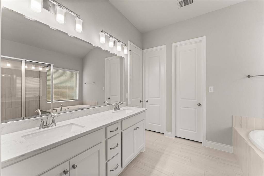 Primary bathroom offers His and Hers closets