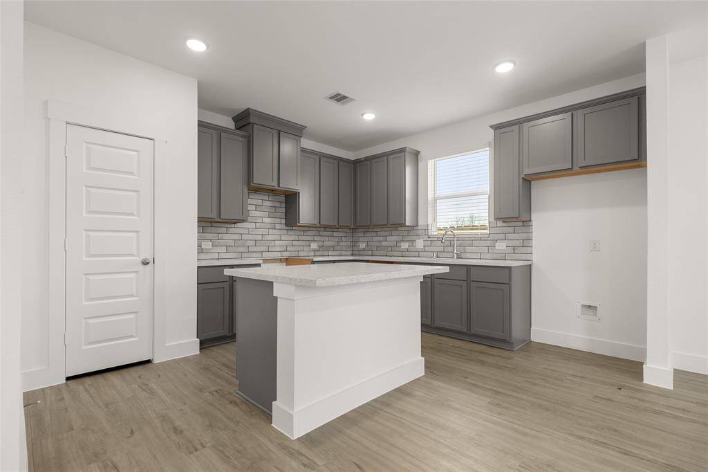 Natural light pours in through large windows, creating a bright and airy atmosphere that makes cooking feel less like a chore and more like a delightful experience. Microwave, Dishwasher, Stovetop range are included, just not pictured.