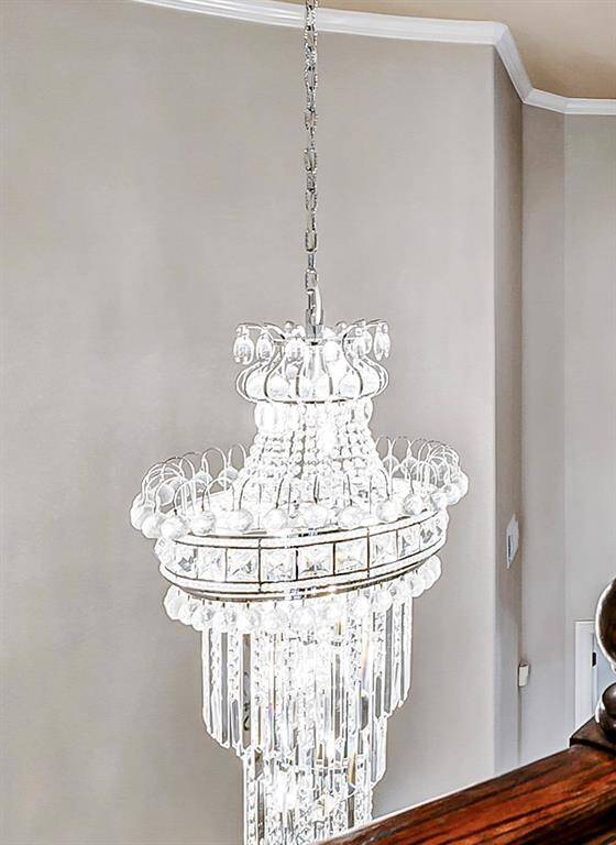 This stunning, sparkling chandelier echoes the graceful curve of the spiral staircase and  will make a lasting impression on your guests!