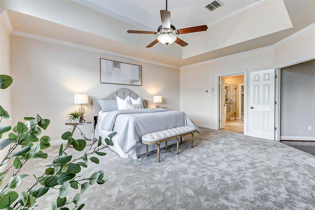 Tucked away on the main floor, this serene carpeted retreat features a recessed ceiling with a central fan and soft ambient light. Generous proportions make it a calm escape at the end of the day.
