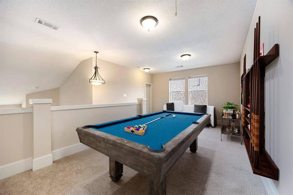 Perfect for entertaining is this amazing game room!  Right upstairs this space would be a fabulous teen hangout, media room, or adult game room complete with pool table and big screen TVs. Featuring plush carpet, high ceilings, dark stained ceiling fan, custom paint and large windows with privacy blinds. *Virtually Staged