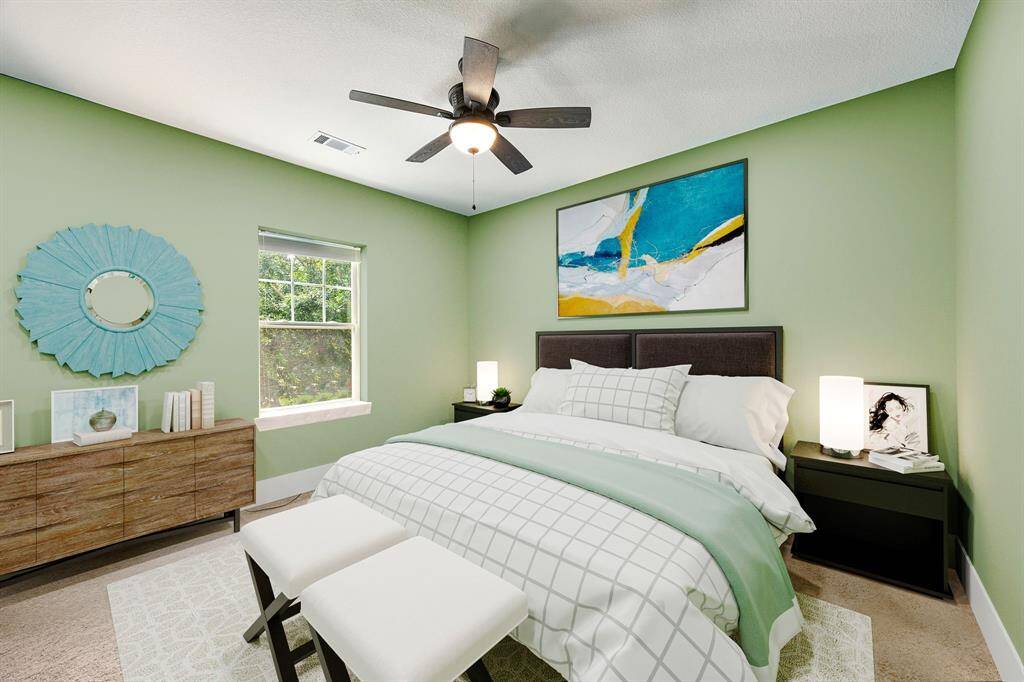 Secondary bedroom features plush carpet, custom paint, dark stained ceiling fan with lighting and a large window with privacy blinds. *Virtually Staged