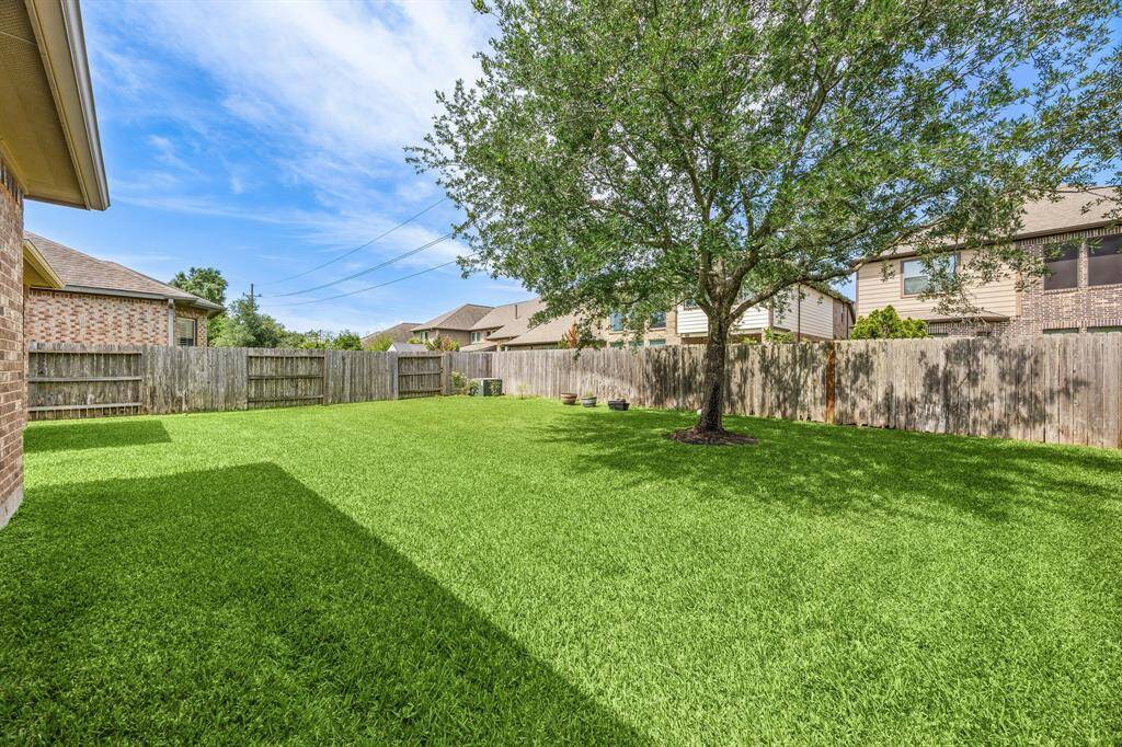 Backyard view showcasing the generous lot size and versatile space, ideal for play, pets, or future landscaping projects.
