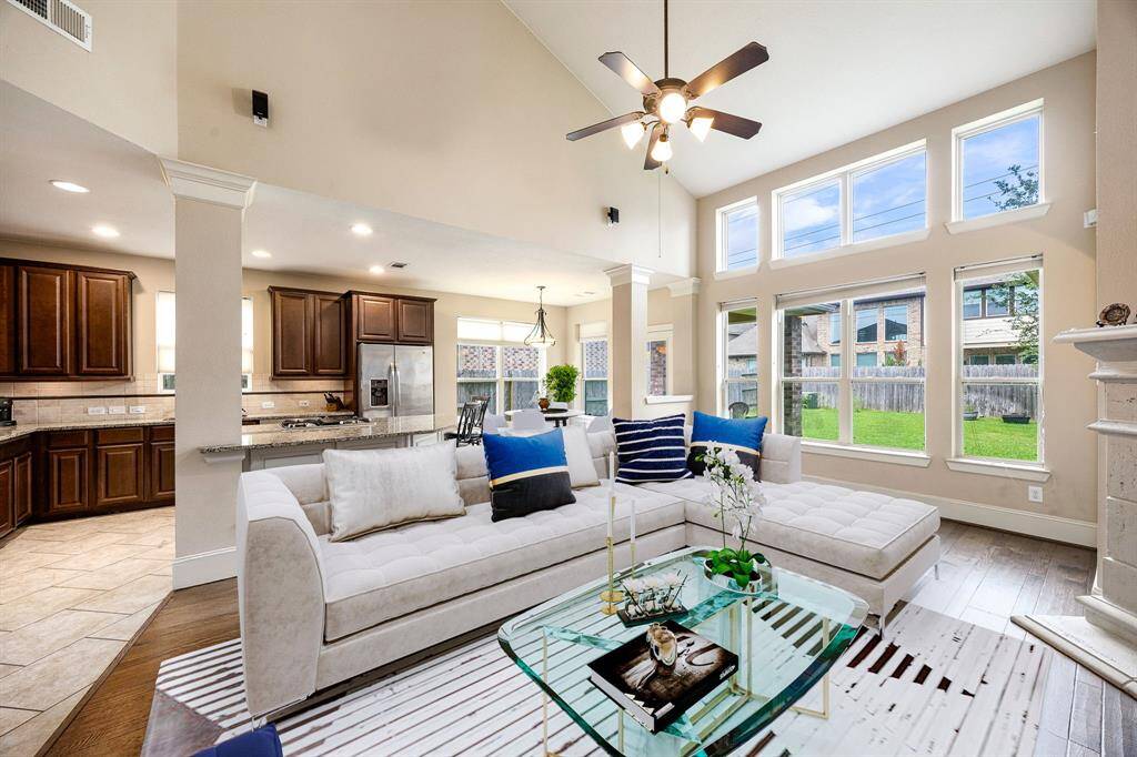 This light and bright spacious living room is the perfect layout for entertaining or just relaxing. Whether it's simply a night in or entertaining family and friends, this home has ample open space for everyone to enjoy! Featuring dark stained ceiling fan, wood style flooring, large windows with blinds, soaring high ceilings, recessed lighting with wonderful access to your gorgeous kitchen. *Virtually Staged