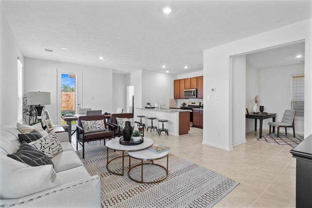As you walk into this beautiful home, you are greeted with the open concept living space. Featuring tile flooring, high ceilings, recessed lighting, large window with blinds, and custom paint!