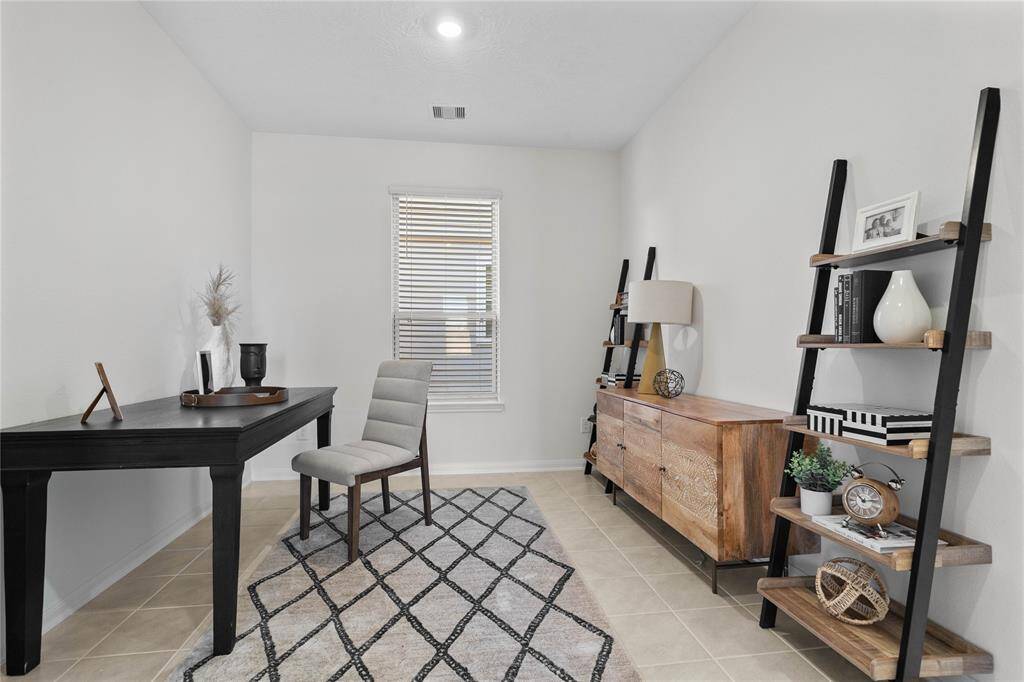 This den is the perfect spot for a home office! Featuring tile flooring, high ceilings, and a large window with privacy blinds.