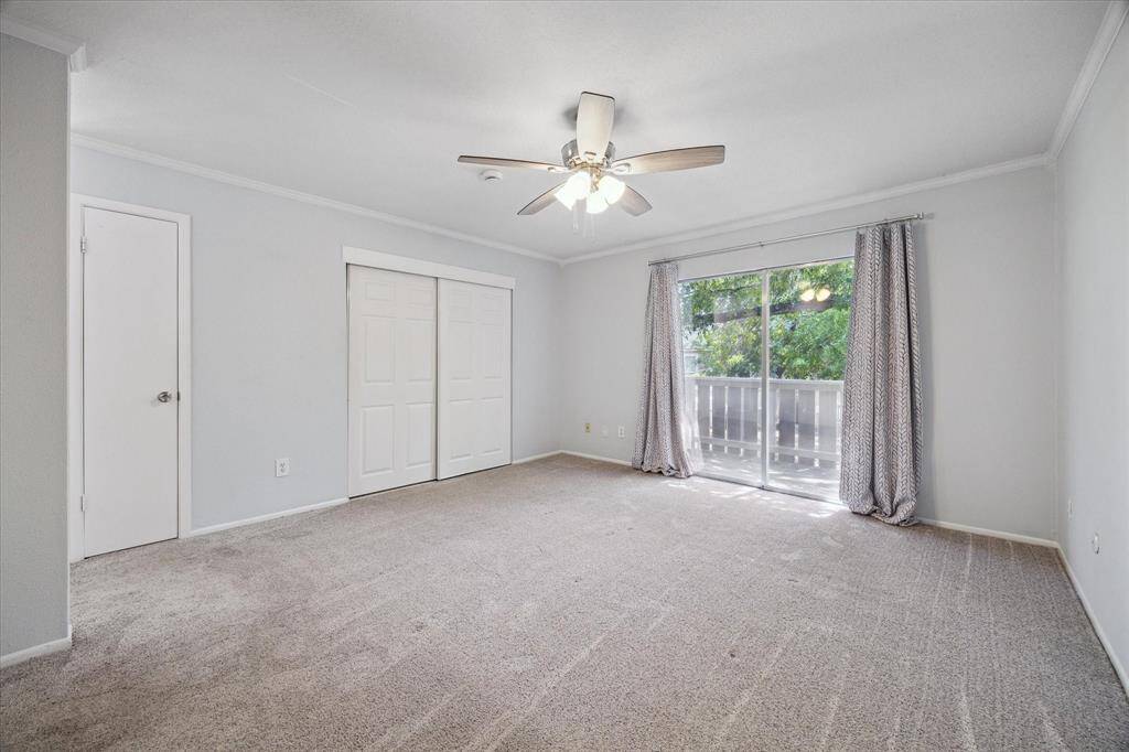 Primary bedroom-This carpeted upstairs bedroom features a ceiling fan, a large sliding glass door leading to a beautiful private balcony. There's also a closet with sliding doors, offering convenient storage.