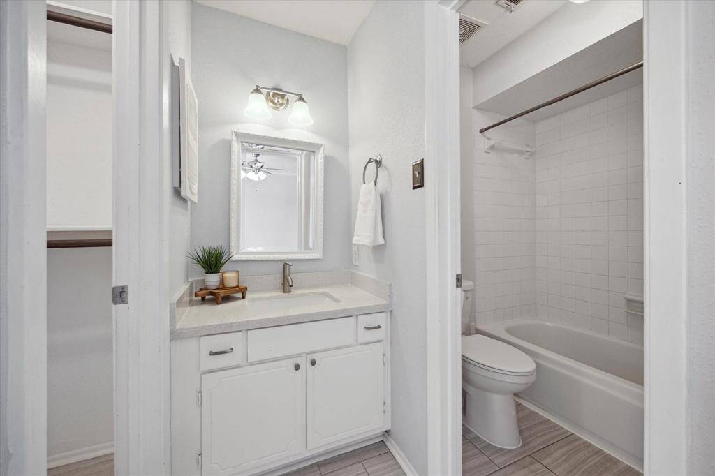 Secondary bathroom with a walk in closet to the left and tub/shower combo to the right.