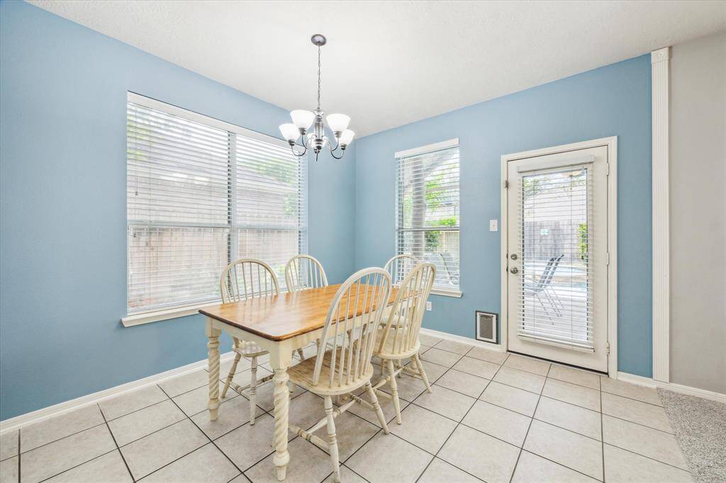 Large windows and a glass door provide ample natural light and a door to the backyard.