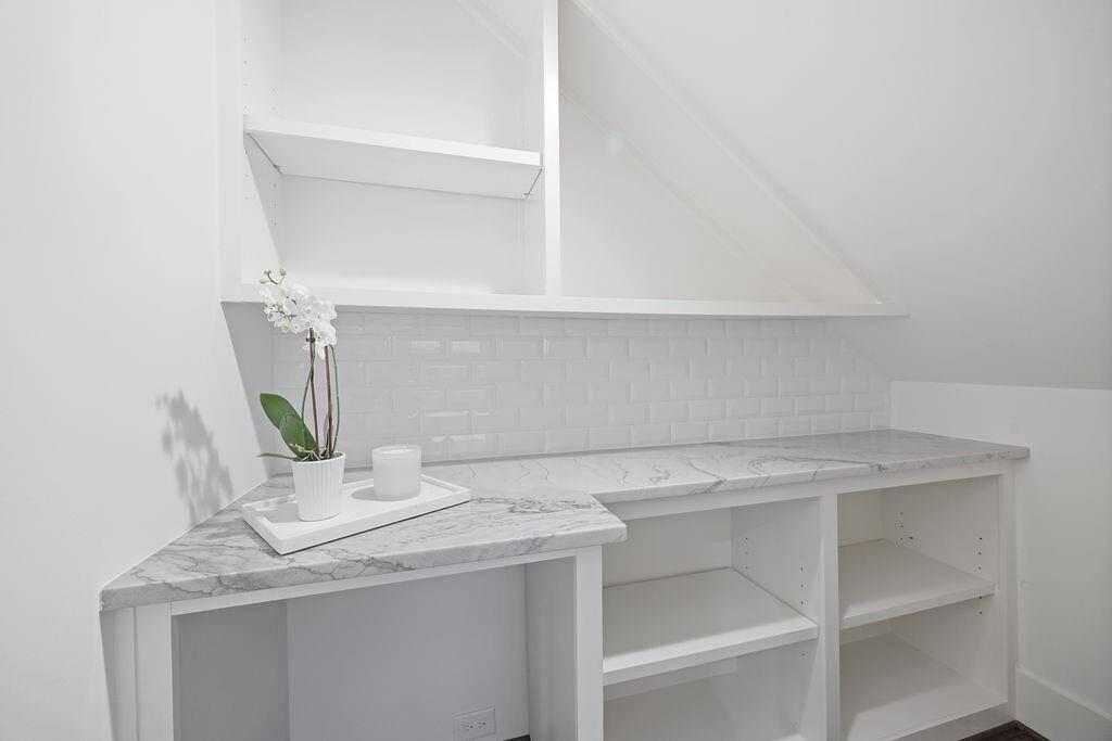 Tucked beneath the stairs, this clever nook adds even more storage and display space. With polished counters and a classic subway tile backsplash, it’s functional, polished, and full of potential.