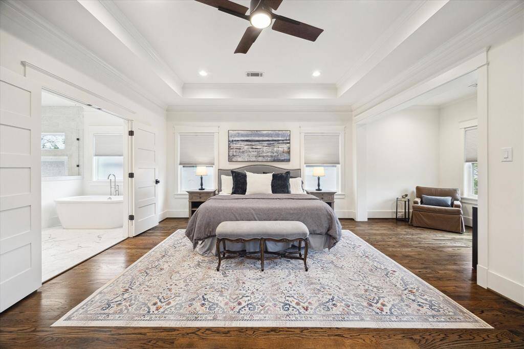 Now this is a primary suite! Flooded with natural light and framed by crown molding and tray ceilings, this spacious retreat easily fits a king bed with room to spare — and did you catch that bonus nook and spa-worthy bathroom? Go ahead…exhale!