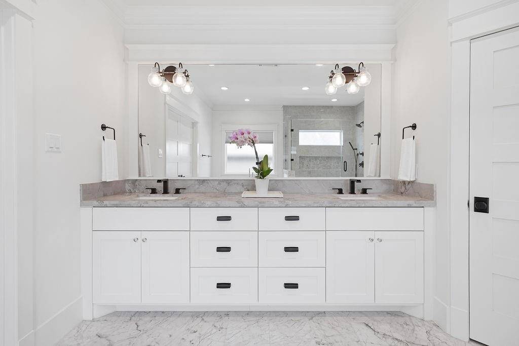 Dual vanities provide ample counter space and storage, with clean finishes and a streamlined look that complements the spa-like feel of the bathroom.