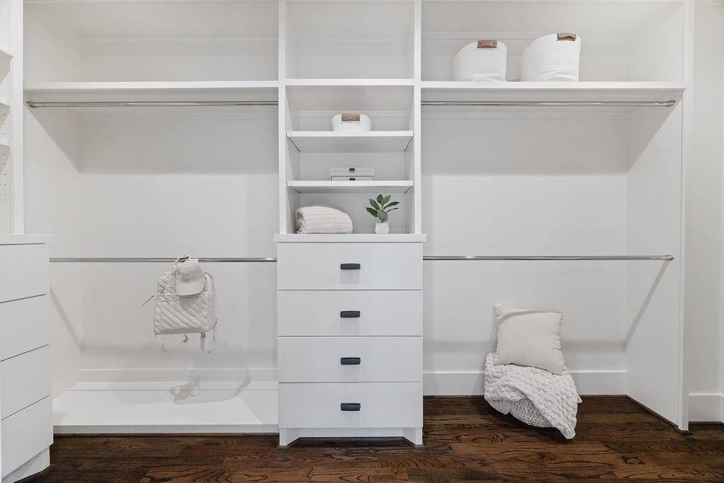 This spacious walk-in closet offers custom shelving, tons of hanging space, and built-in drawers to keep everything organized.