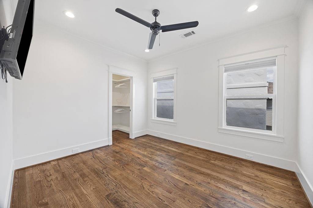 One of two secondary bedrooms connected by a stylish dual-entry bath, with wood floors, recessed lighting, and a walk-in closet.