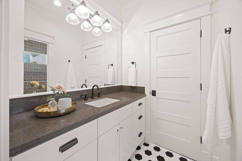 This shared bath between two of the upstairs bedrooms features a wide vanity with generous storage and graphic tile flooring.