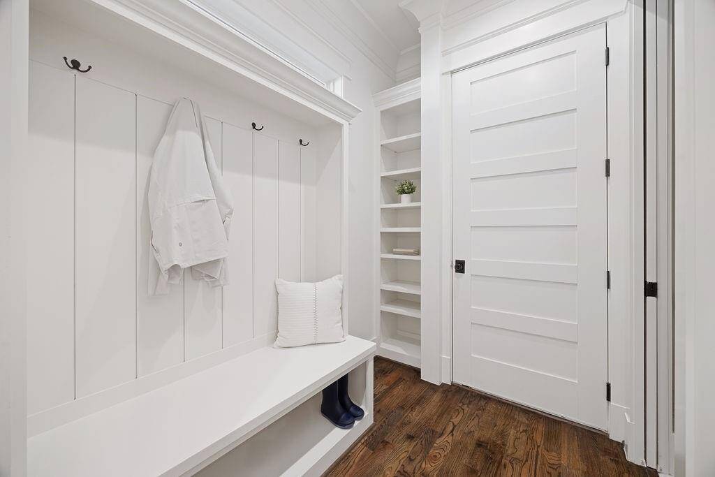 Convenient mudroom off the garage entry with built-in bench, hooks, and open shelving to keep things neat and organized.