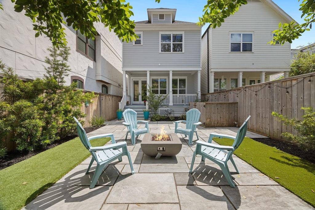 Enjoy year-round outdoor living with a covered porch that opens to a private backyard featuring a built-in gas fire pit, low-maintenance turf, and an extra-tall privacy fence—perfect for relaxing or entertaining.