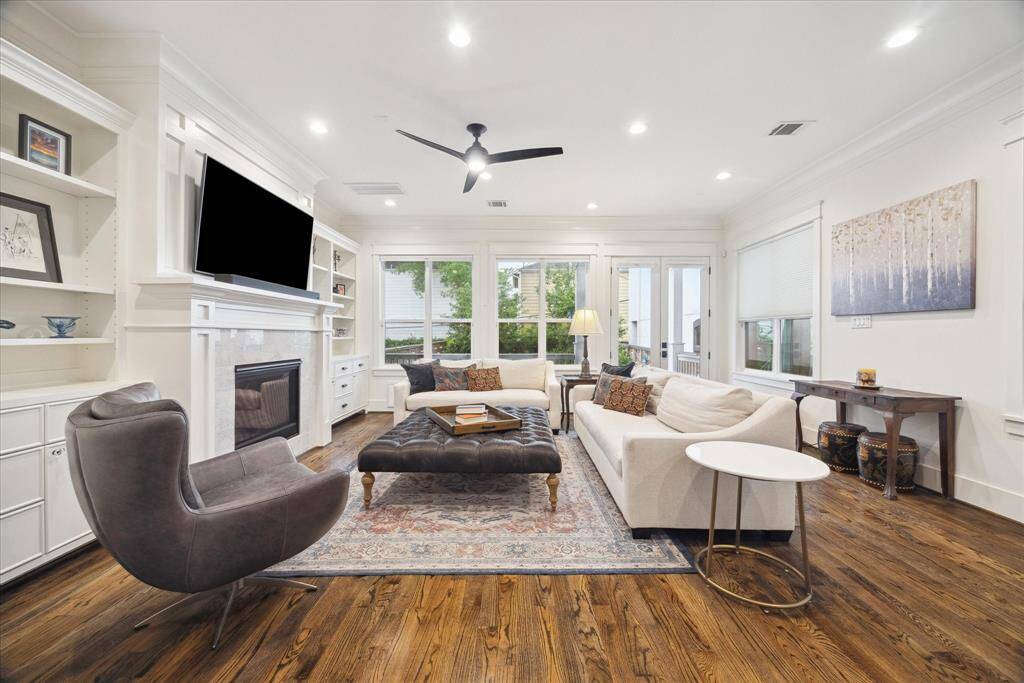 Bright and welcoming, this cozy living room feels like home, inviting you to unwind by the gas fireplace framed by custom built-ins. French doors lead to the covered deck and backyard.
