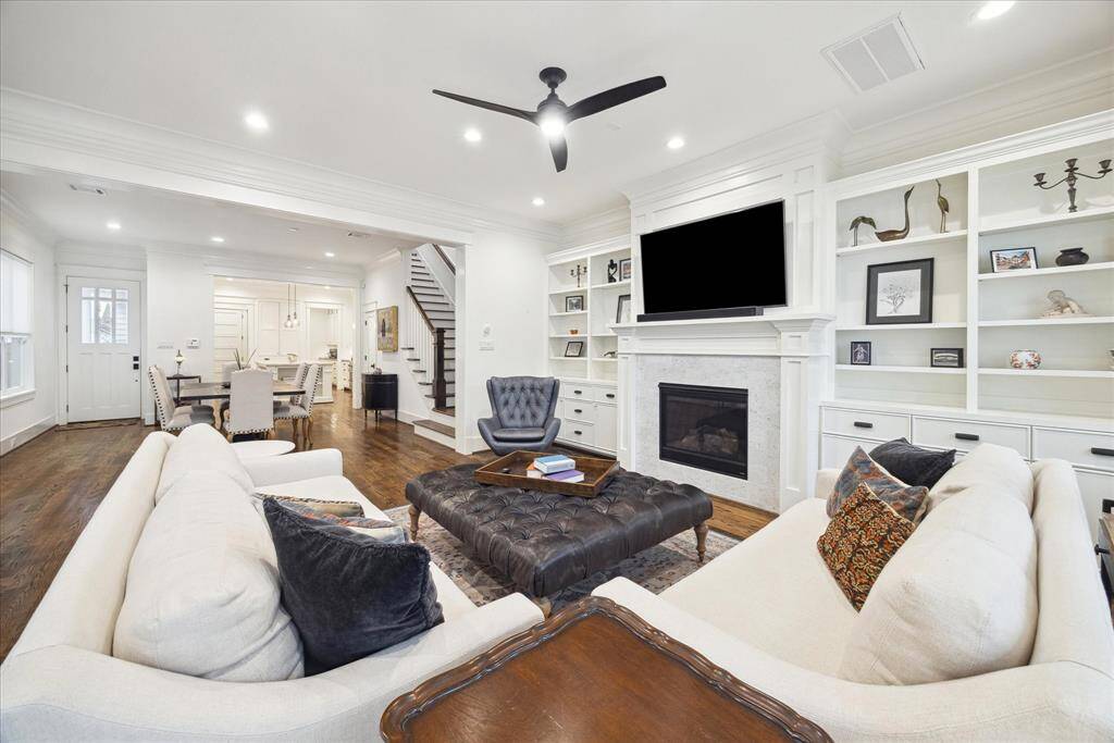 The open-concept living area flows into the kitchen and dining spaces, all framed by elegant double crown molding that carries throughout the home.
