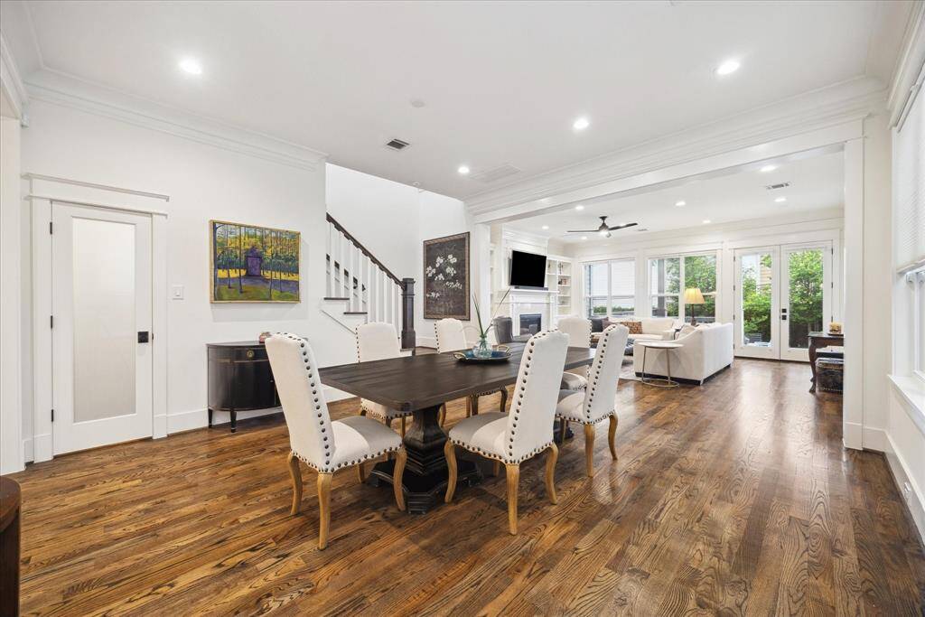 The dining area sits at the center of the home’s open-concept layout, comfortably bridging the kitchen and living room. Surrounded by oversized windows and framed in double crown molding, it’s an inviting space for entertaining and everyday meals.