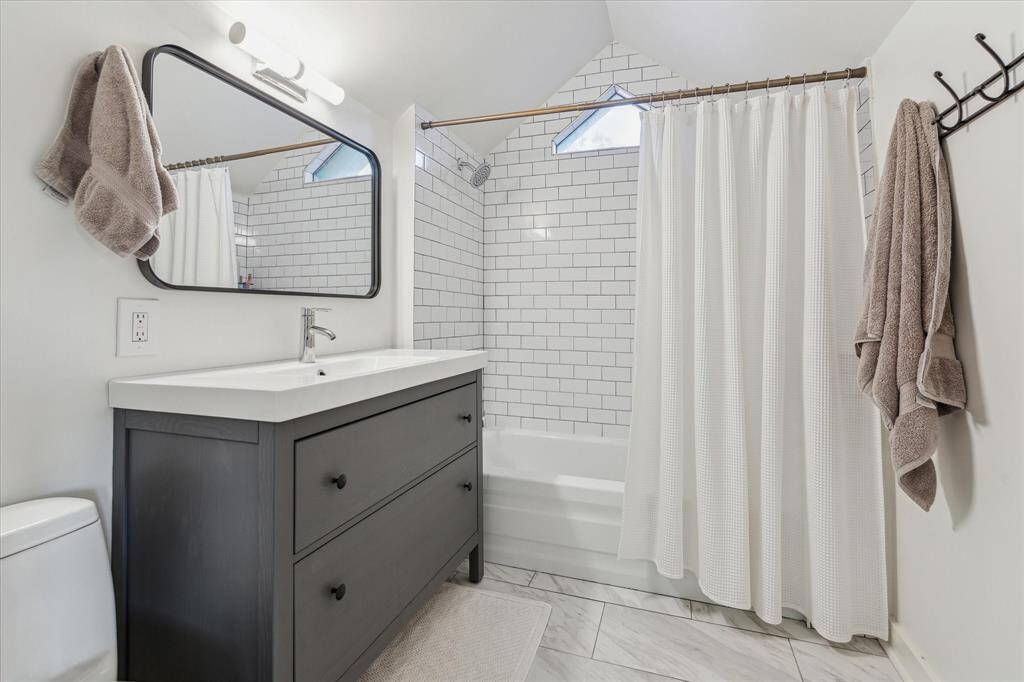 Enter into primary bath with vanity storage, dual tub and shower while being accented with subway tile and stone tile.
