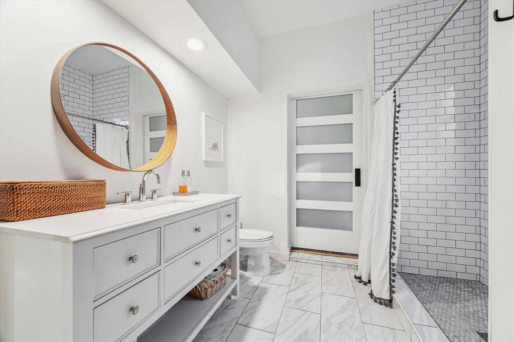 Secondary bathroom with noteworthy upgraded shower detail and attention to detail continued and useful use of storage.