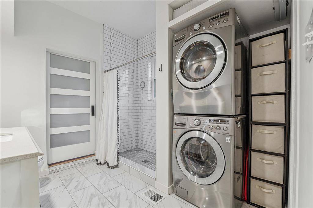 Secondary bath encompasses full size stacked washer/dryer for convenience.