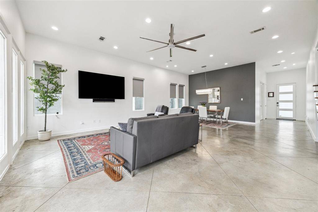 Elegant living/dining area featuring a radiant LED chandelier and smart rechargeable darkening shades for ambiance control.