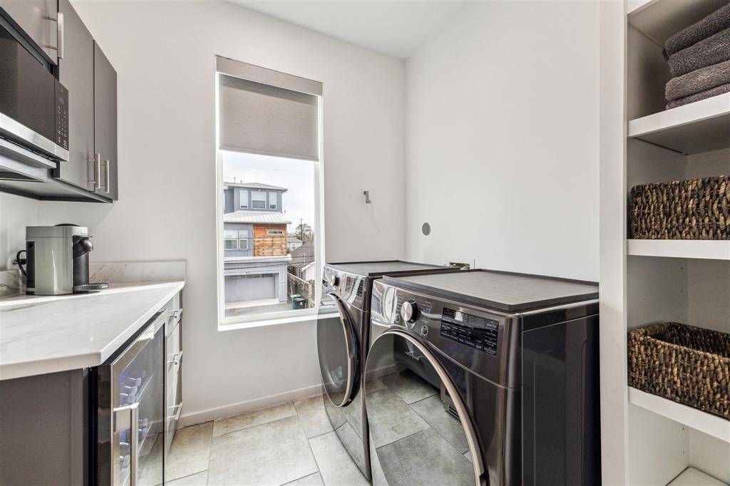 Convenient laundry with a new mini bar, beverage fridge, and microwave, blending practicality and style.