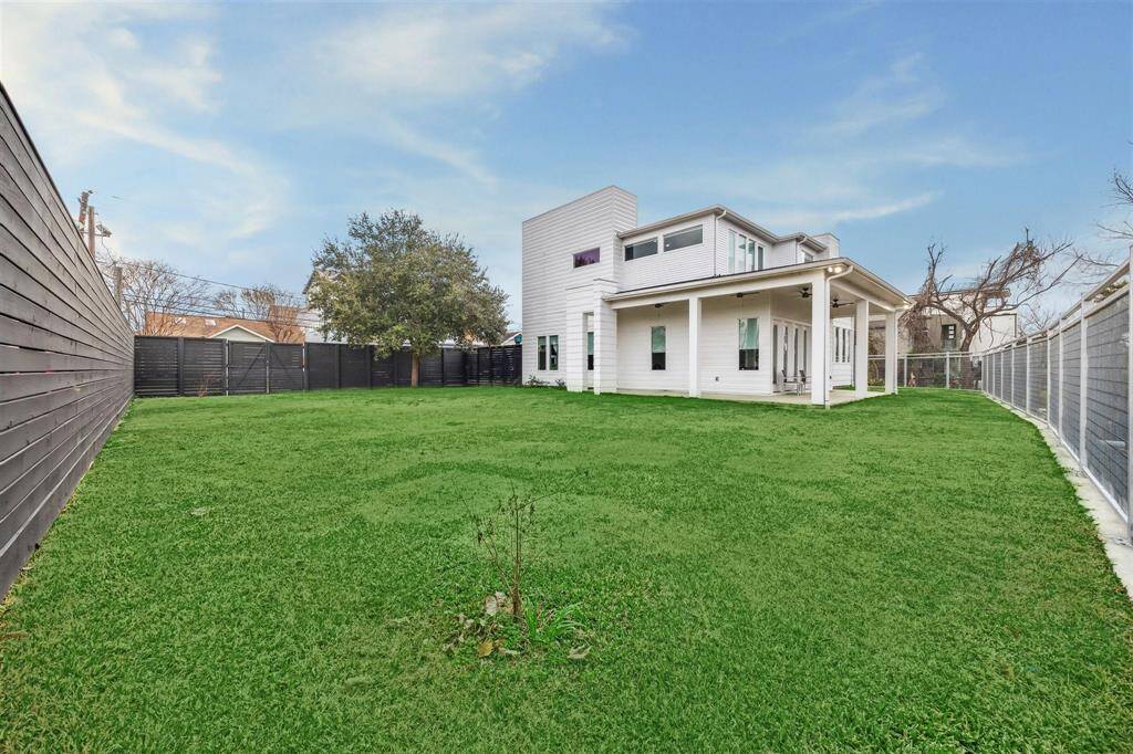 Private, fully fenced backyard with a durable 8’ wood fence, stained deck boards, metal fence, and lush St. Augustine sod.