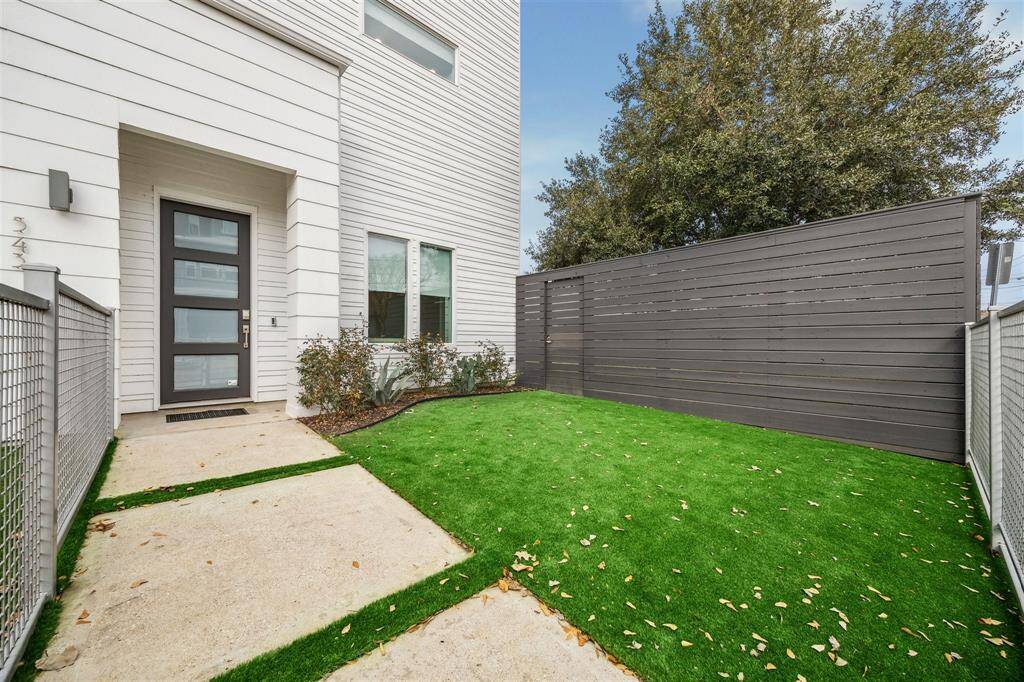 Low-maintenance front yard with pristine new artificial turf, offering a lush, green look year-round.