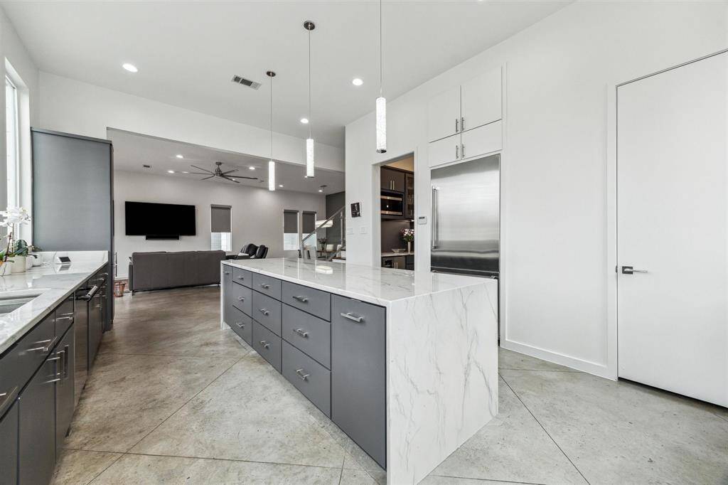 Elegant kitchen with soft-closing drawers, cabinets, and modern LED pendants illuminating the space.