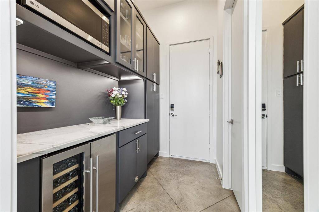 Chic kitchen featuring a new bar area with under-cabinet lighting and a sleek built-in microwave.