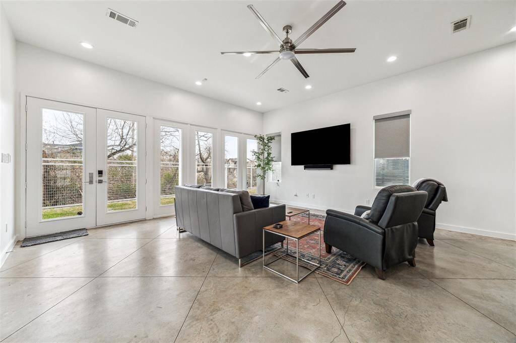 Bright living area with abundant natural light, a dazzling new LED chandelier, and smart rechargeable darkening shades.
